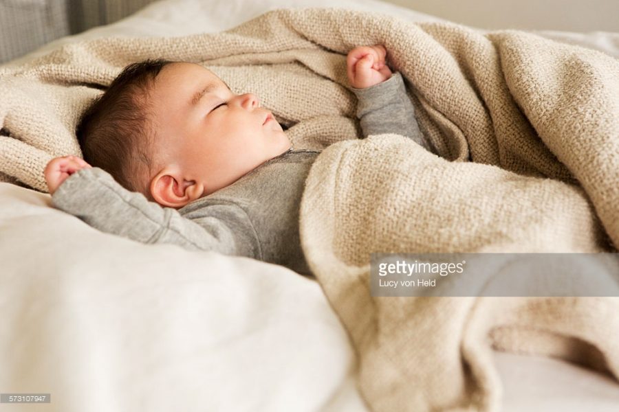 Mixed race baby sleeping in bed