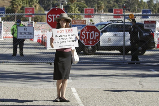 An anti-vax protester criticizes the Moderna COVID-19 vaccine at the Dodger Stadium vaccination site. She is one of many demonstrators who participated in a protest on the afternoon of January 30, assembled by the organization Shop Mask Free Los Angeles. Photo courtesy of The Los Angeles Times.
