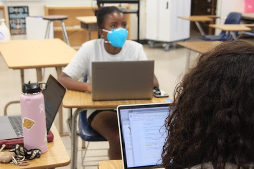 Indoors and masked, Adaora Enyekwe (12) meets with her fellow Yearbook editorial staff. Enyekwe, who is involved with UNICEF, Key Club, and Yearbook, has seen first-hand how COVID-19 guidelines have changed club meetings. The way Key Club has run its board meetings is to “start in the very beginning, and then leave early to have lunch.” Photo courtesy of Kaila Uyemura (12).