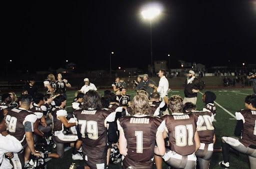 Varsity Football takes a knee minutes before the game, receiving words of encouragement from their coach. “Youll be fifteen years down the line and youll remember that one Homecoming game … when you have kids you will be able to tell them how it was for you,” Varsity player Juan Garcia (12) joyfully said.