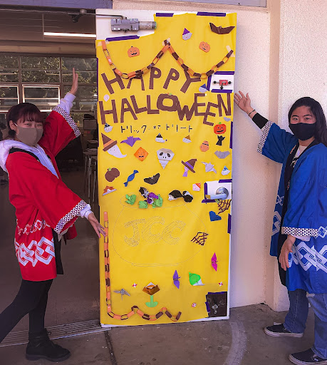JCC President Fusako Maekawa (12) and Vice President Julie Kimura (12) show off their spooky, bi-cultural door that won first place in the Halloween Door Decoration Contest. Maekawa explained that their goal was to use “Japanese crafts like origami to show [the] American culture [of] Halloween.” The club meets in Room 4105. Photo courtesy of Fusako Maekawa (12).