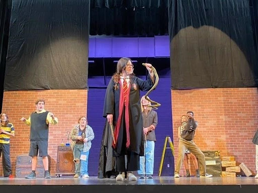 The 2021 show by the West High Theater Department follows the Hufflepuff house during Harry Potter’s seven years at Hogwarts. To prepare for opening night, students gather around to make wands, practice lines, and practice in costumes. Photo courtesy of Isabella Distasio (11).