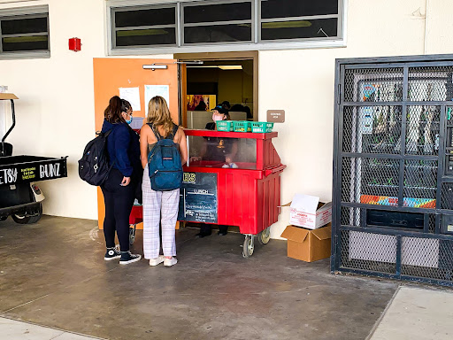Two students get lunch at the Red Cart located in Cafe 5. Giving free food to students is crucial, especially in a time of high financial stress for many families. TUSD has been providing free meals since COVID-19 hit last year.