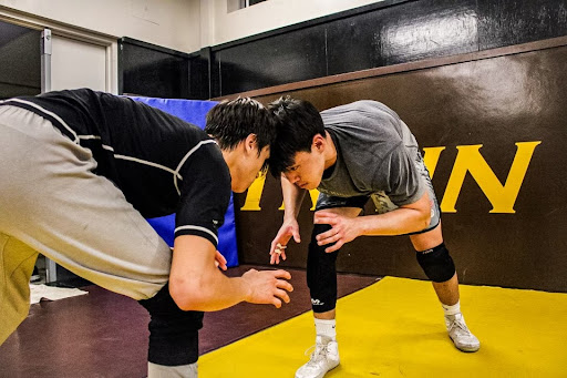 Butting heads, wrestlers Michael Barretto (12) and David Lee (12) practice their skills. They have prepared hard to win their competitions and have a successful season!