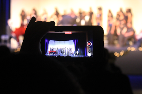 Cameras of friends, families, and guardians are aimed at the stage, seen from every other seat. After a year devoid of concerts on West’s campus, the 2021 Winter Wonderland Concert was important for many. From filming Instagram stories to posting on family Facebook pages, this was an important moment to record. Nervous performers knew the significance of the event, so choir director Mr. Dowdle advised them to “just relax. Enjoy yourself. Everything else will be okay.” Photo courtesy of Naoya Yoshimura.

