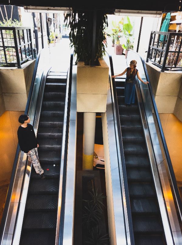 Dadivas and Fontanilla stand fashionably on the outdated escalators of Old Torrance. The escalators added a level of aesthetic -  the blending colors of their grunge-inspired fall outfits and the worn out escalator stairs - making their styles timeless. (Art/Photo by Darren Kawazoe)