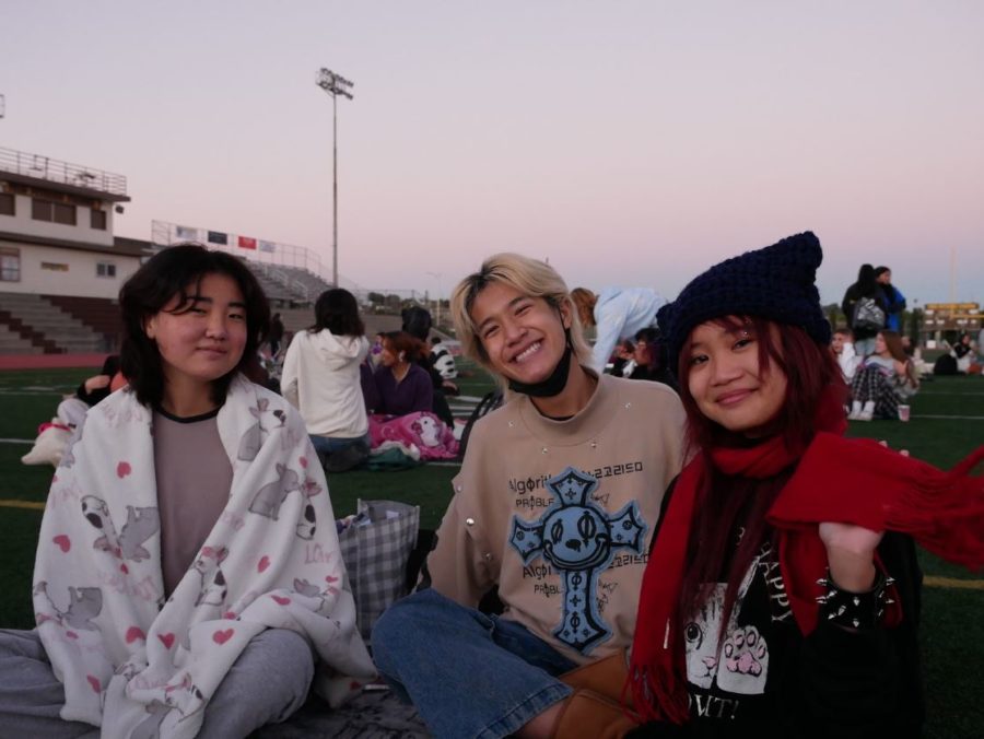 Sorina Yang (12), Tommy Nguyen (12), and Kayla Dadivas (12) warm up on a pile of blankets. Gathered together at the football field, the class of 2023 enjoyed the last taste of their highschool careers as they head towards their own paths in the future. Senior Sunrise is a meaningful event to many, including  Nguyen, who found it bittersweet: “To me, it meant an opening into the last year of high school surrounded by all the people I grew up with.” 