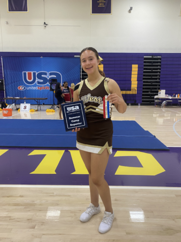 Cheerleading captain Eva Reyes (12) grins as she lifts her Superior award for the United Spirit Association competition. Despite the hardships that come with her leadership role, Reyes still finds passion and joy in cheerleading, even with the challenges that come with it: “I love it as a whole and everything that comes with it, even the conditioning — I don’t mind it because it’s doing what I love,” she explained. 
Photo courtesy of Eva Reyes (12). 