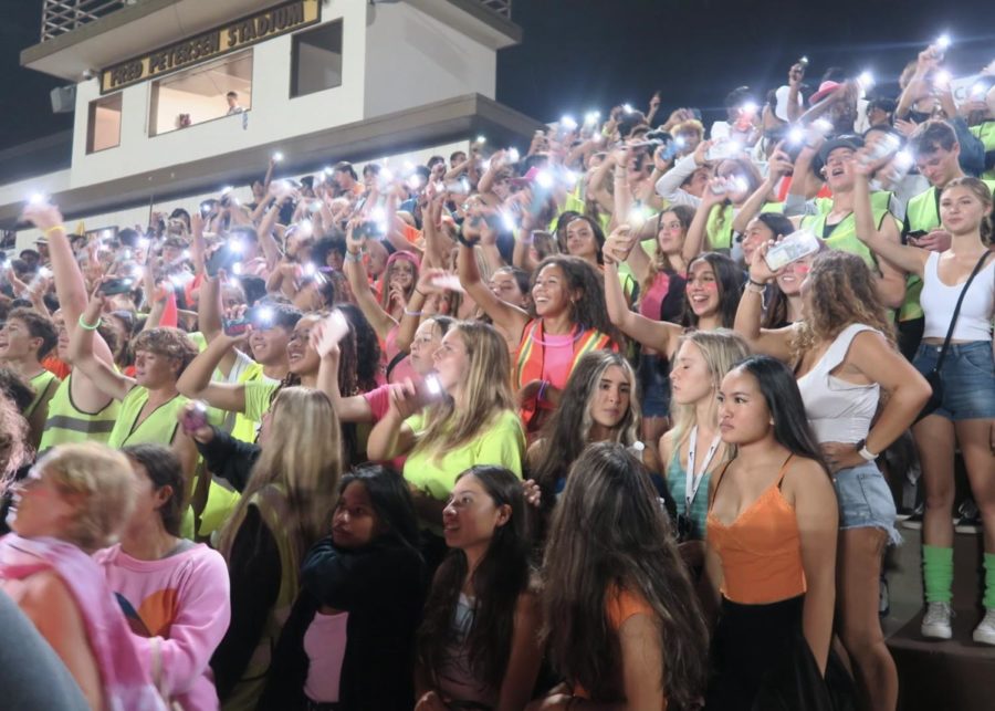 Students wave their flashlights in time with music to show support for the Football Team at West High’s first football game.