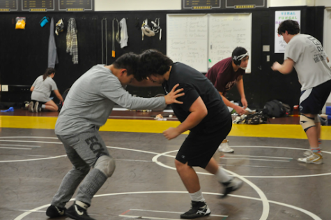 Enoch Joo (11), pictured left, wrestles Coach Diego, a Redondo Union graduate who comes in to help at West practices. As they grappled, three other coaches (out of frame) sat quietly as they observed the room; practice had just begun.