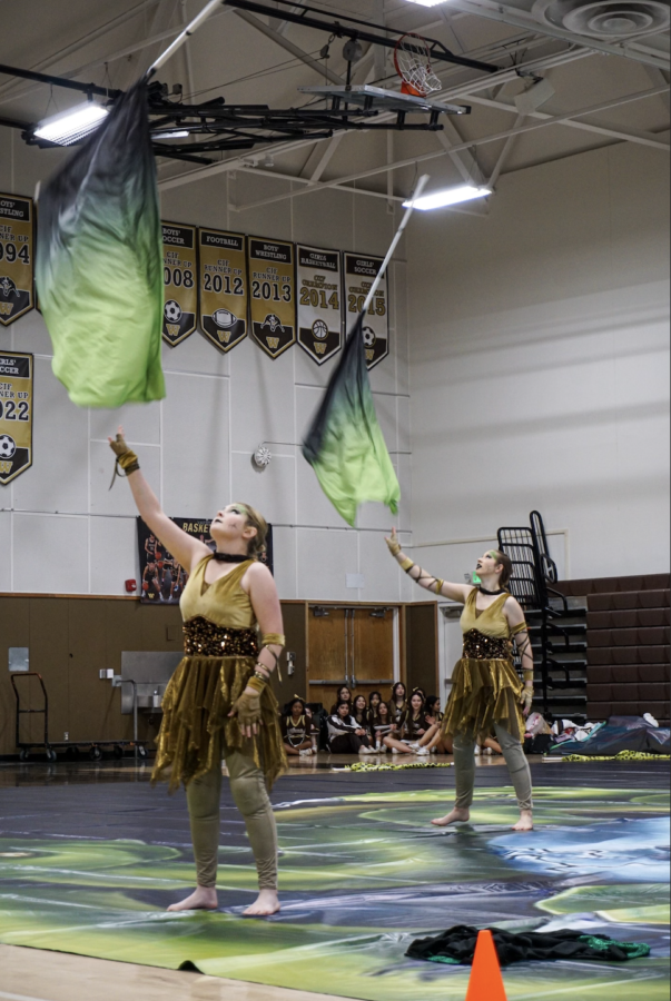 Perfectly in sync, Claire Perry (12) and Amanda Bruers (10) toss their flags in a performance  titled “Medusa.” Photo courtesy of Marina Soen (12).