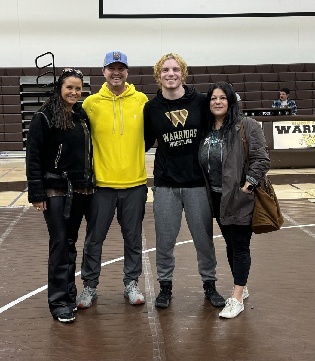 Ethan Rogers (12), post-wrestling-match, shares a triumphant moment with his family. With smiles written across their faces, this encapsulated the pinnacle of Rogerss wrestling journey. 