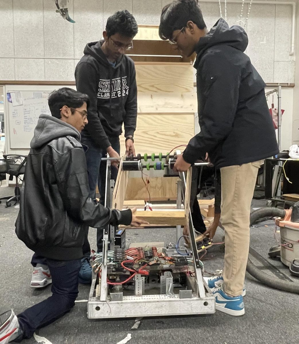 On Tuesday, Jan. 16, members of the robotics team construct and build upon one of their many prototypes. Pieces of machinery like this one are one of several required to build the finished robot. From left to right: Rugved Patil (11), Advait Sawalkar (12), Ishan Samarasinghe (12). 