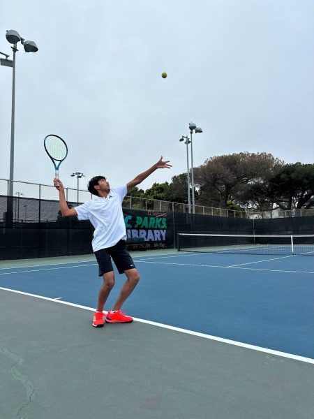 Rishabh Raikar (10) practices his serves before his singles match against El Segundo. At the start of the tennis game, players warmed up by hitting forehands, backhands, and readying their volleying skills. Photo courtesy of Dowon Kang (12).
