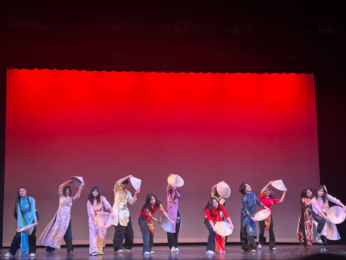 (Left): GSA performers wave the non-binary flag during their fashion show on Multicultural Day as Sydney Joseph reads off facts about this gender identity. The flag was one of many that this club displayed at the event. They each symbolized a different group of people within the LGBTQ+ community. 