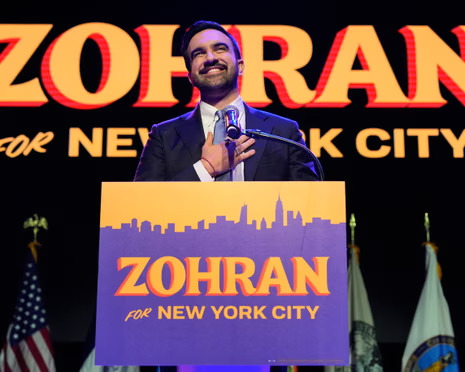 Mayor-elect Zohran Mamdani smiles at a podium during his victory speech in New York City. He defeated former Governor Andrew Cuomo and Republican Curtis Sliwa in the November 2025 election to become the city's first Muslim mayor.  In addressing voters’ questions, he pledged to freeze rents and implement free bus service as part of his "affordability agenda" for working-class New Yorkers, showing his dedication to his big dreams for the people he now proudly serves. 
